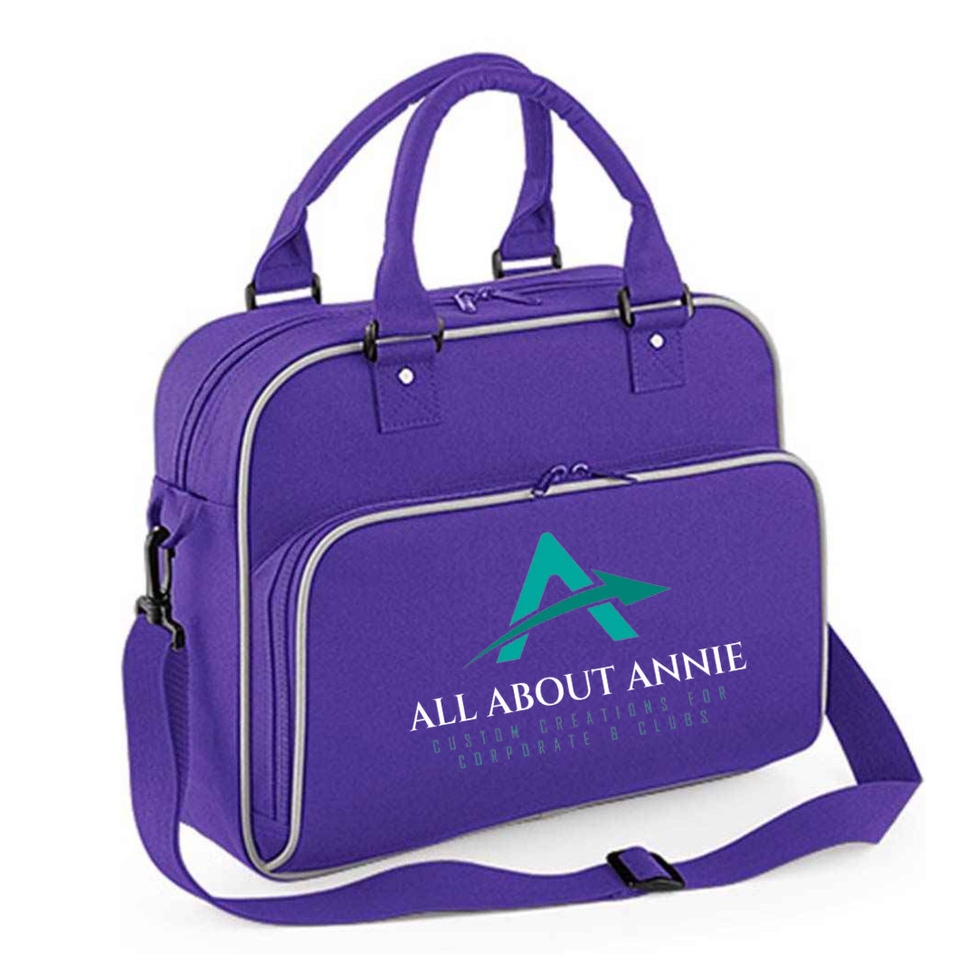 A black Hold-All Bag with 'All About Annie' branding in white and teal on the front. The bag has a zippered closure and an adjustable crossbody strap.